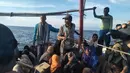 Pengungsi etnis Rohingya berada di atas kapal setelah terdampar di pesisir Pantai Seunuddon, Aceh Utara (24/6/2020). (INDONESIAN NAVY / AFP)