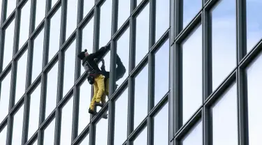 Alain Robert ketika memanjat gedung di pusat bisnis La Defense, Paris, Prancis, Senin (21/3/2016). Pria yang dijuluki 'Spiderman' ini telah memanjat lebih dari 70 gedung tertinggi di dunia. (Jacques DEMARTHON/AFP)