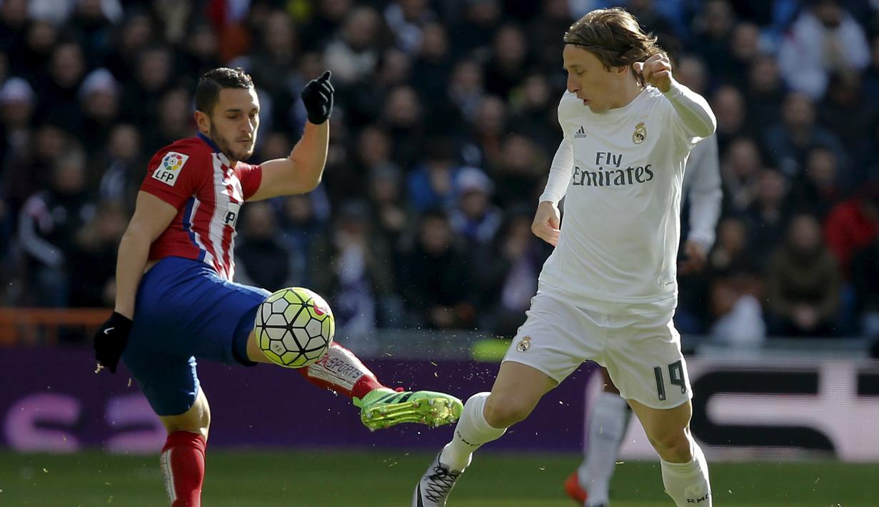 Pemain Real Madrid, Luka Modric menghalau bola dari sepakan pemain Atletico Madrid, Jorge "Koke" Resurrecion pada lanjutan La Liga Spanyol pekan ke-26 di Stadion Santiago Bernabeu, Sabtu (27/2/2016) Malam WIB. (REUTERS/Sergio Perez)