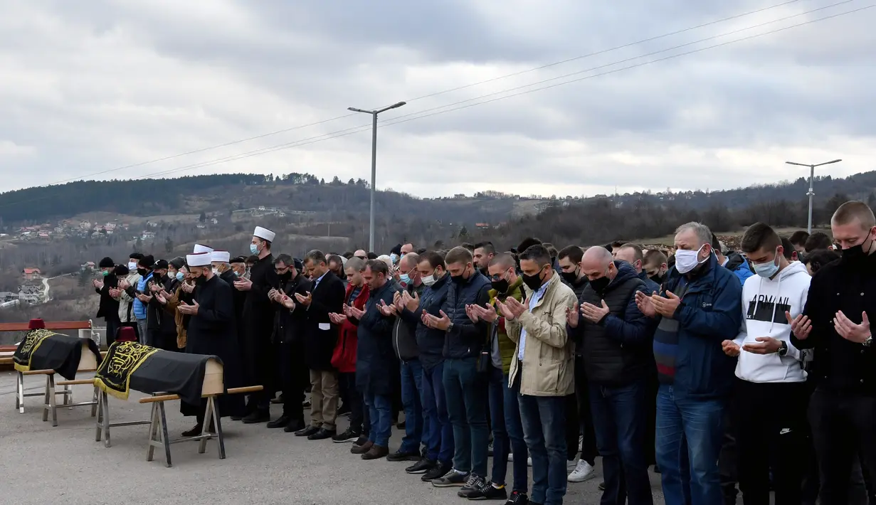 Para pelayat menghadiri pemakaman jenazah yang meninggal akibat komplikasi terkait COVID-19 di pemakaman Sarajevo Vlakovo, Bosnia, Jumat (19/3/2021). Rumah sakit dan kamar mayat di Sarajevo kewalahan mengatasi meningkatnya infeksi dan lonjakan kematian yang disebabkan oleh virus corona. (AP Photo)