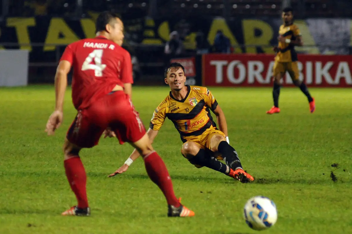 Penyerang Mitra Kukar, Rodrigo (tengah) terpeleset saat mencoba masuk kedalam pertahanan  Semen Padang pada laga final Piala Jenderal Sudirman di Stadion GBK Jakarta, Minggu (24/1/2016). Ini   pertemuan ketiga bagi kedua tim. (Liputan6.com/Helmi Fithrians