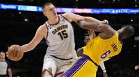Pebasket Denver Nuggets, Nikola Jokic (kiri), berusaha melewati penjagaan pebasket LA Lakers, LeBron James, dalam final NBA 2023 game keempat wilayah barat di Crypto.com Arena, Selasa (23/5/2023) pagi WIB. (AP Photo/Ashley Landis)