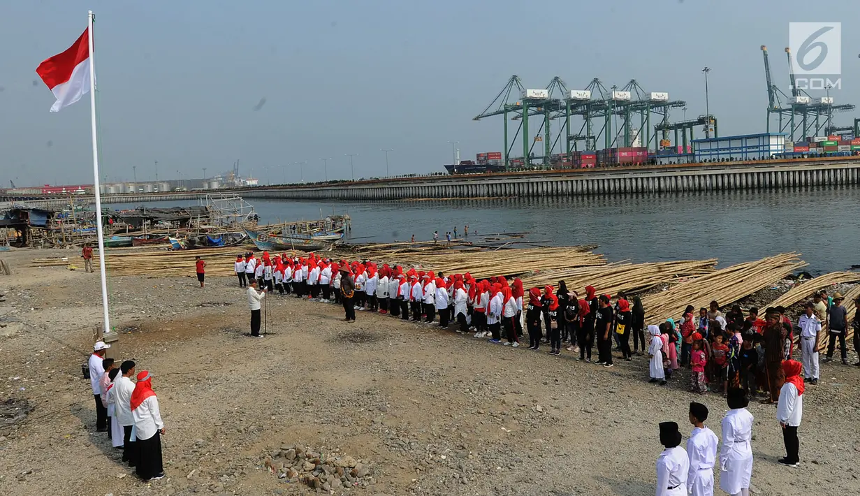 Warga pesisir pantai Cilncing melakukan upacara bendera HUT ke-74 Ri di pinggir pantai, RW 04, Cilincing, Jakarta Utara, Sabtu (17/8/2019). Kegiatan yang diikuti warga RW 08 Manunggal ini diprakarsai Kelas Jurnalistik Cilik dalam rangka memupuk  rasa kebangsaan. (merdeka.com/Arie Basuki)
