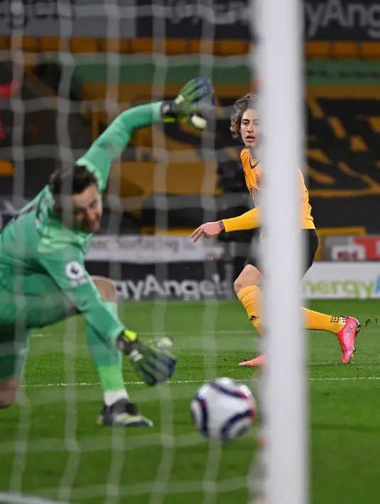 Striker Wolverhampton Wanderers, Fabio Silva (kanan) menembak melewati kiper West Ham United, Lukasz Fabianski untuk mencetak gol dalam laga Liga Inggris pekan ke-30 di Molineux Stadium, Selasa (6/4/2021) dini hari WIB. West Ham menang 3-2 di kandang Wolverhampton. (Laurence Griffiths/POOL/AFP)