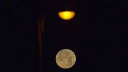 Pemadangan saat bulan terbenam di balik awan di laut Mediterania di lepas pantai Hadera, Israel, Rabu (31/1). (AP Photo / Ariel Schalit)