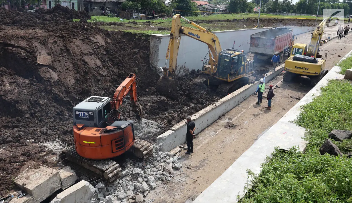 Sejumlah alat berat mengeruk longsoran tanah di Underpass Perimeter, Bandara Soetta, Tangerang, Banten, Selasa (6/2). Selain membersihkan longsor, alat berat juga dikerahkan untuk mengevakuasi mobil yang tertimbun. (Liputan6.com/Angga Yuniar)