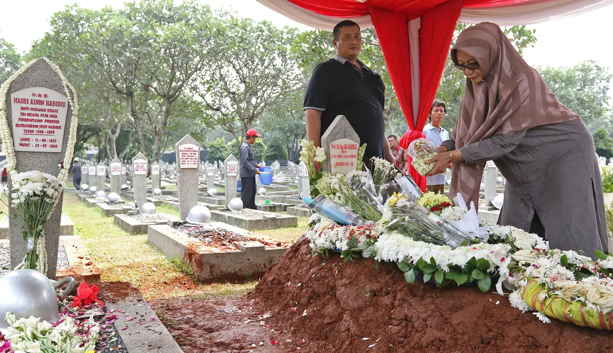 Warga menaburkan bunga di makam Presiden ke-3 RI BJ Habibie yang bersebelah dengan sang istri, Hasri Ainun Besari di TMP Kalibata, Jakarta, Jumat (13/9/2019). Sesuai permintaannya semasa hidup, Habibie dimakamkan bersebelahan dengan mendiang istrinya, Ainun. (Liputan6.com/Herman Zakharia)