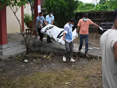 Petugas kesehatan membawa jenazah korban banjir bandang untuk dikremasi di luar kamar jenazah di distrik Chitwan, Nepal, Senin, 31 Agustus 2026. (AFP/ Prakash Mathema)