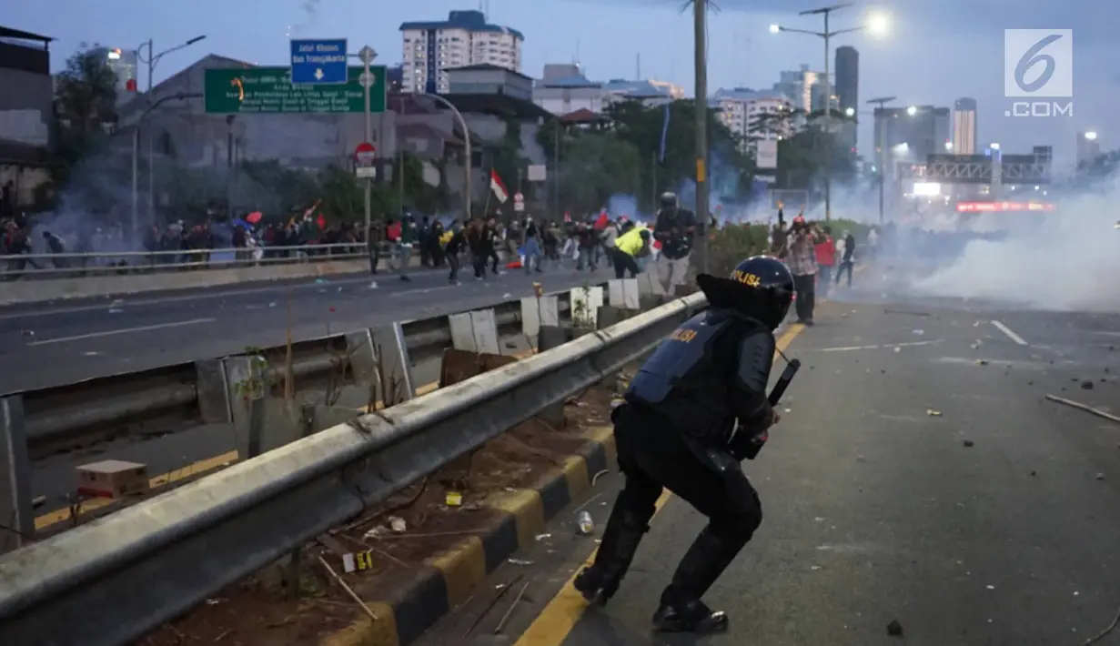 Aparat kepolisian melepaskan tembakan gas air mata untuk membalas serangan petasan yang dilemparkan oleh demonstran di sekitar Gedung DPR RI, Jakarta, Senin (30/9/2019). Demo mahasiswa dan sejumlah elemen tersebut berakhir dengan bentrok dengan polisi. (Liputan6.com/Immanuel Antonius)