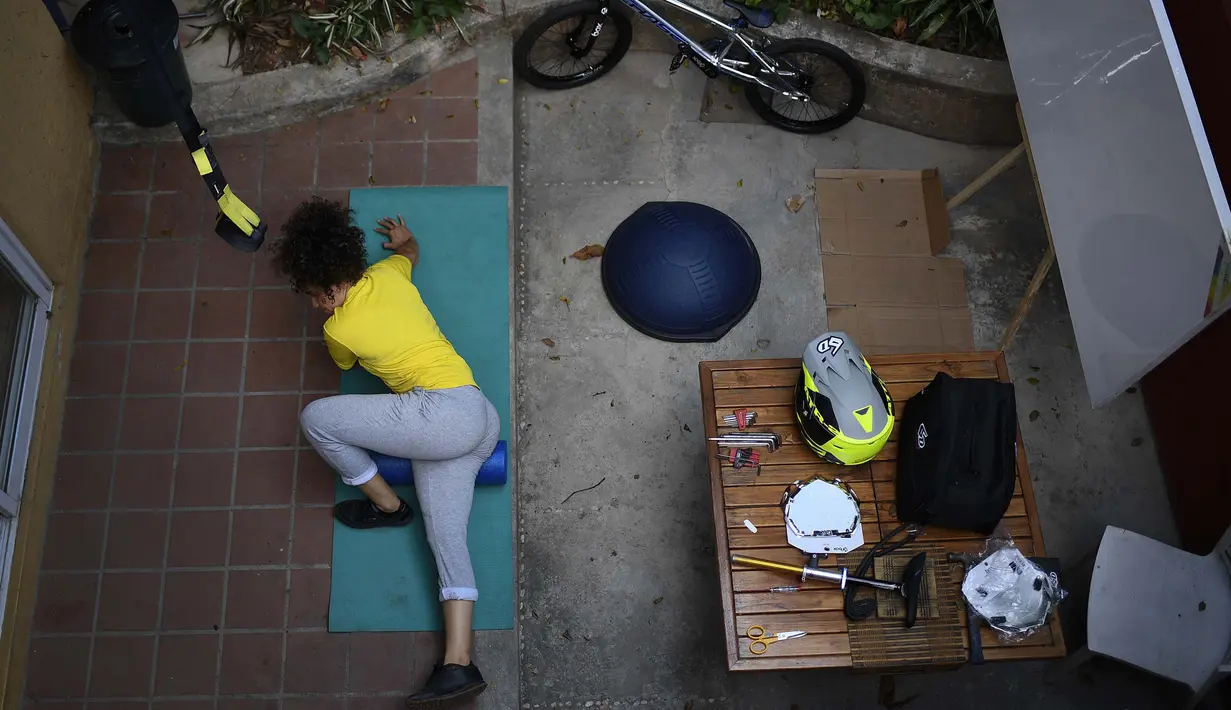 Atlet BMX asal Venezuela, Stefany Hernandez melakukan peregangan di rumahnya di Caracas, 25 April 2020. Di tengah karantina wilayah guna mengekang penyebaran Covid-19, peraih medali Olimpiade 2016 itu berlatih tiga kali seminggu untuk meraih tiket tampil di Olimpiade 2021. (AP/Matias Delacroix)