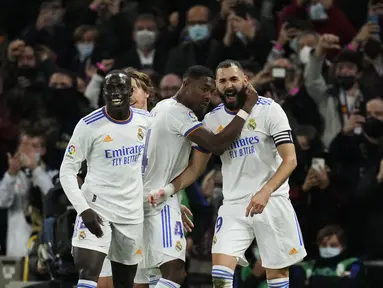 Penyerang Real Madrid, Karim Benzema (kanan) berselebrasi dengan timnya setelah mencetak gol ke gawang Atletico Madrid pada pekan ke-17 Liga Spanyol di Santiago Bernabeu, Senin dini hari WIB (13/12/2021). Real Madrid menaklukkan rival sekotanya Atletico Madrid 2-0. (AP Photo/Bernat Armangue)