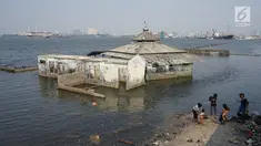 Bangunan tempat ibadah berada di perbatasan laut dan daratan di kawasan Muara Baru, Jakarta Utara, Selasa (30/7/2019). Naiknya permukaan air laut selama bertahun-tahun menyebabkan kawasan tersebut terendam banjir hingga menyatu dengan lautan. (Liputan6.com/Immanuel Antonius)