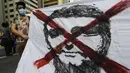 Seorang demonstran memegang spanduk dengan tanda x di atas gambar Presiden Brasil Jair Bolsonaro, di Sao Paulo, Sabtu (3/7/2021). Protes ini dipicu oleh tuduhan korupsi baru-baru ini yang melibatkan pembelian vaksin COVID-19 oleh kementerian kesehatan. (AP Photo/Nelson Antoine)
