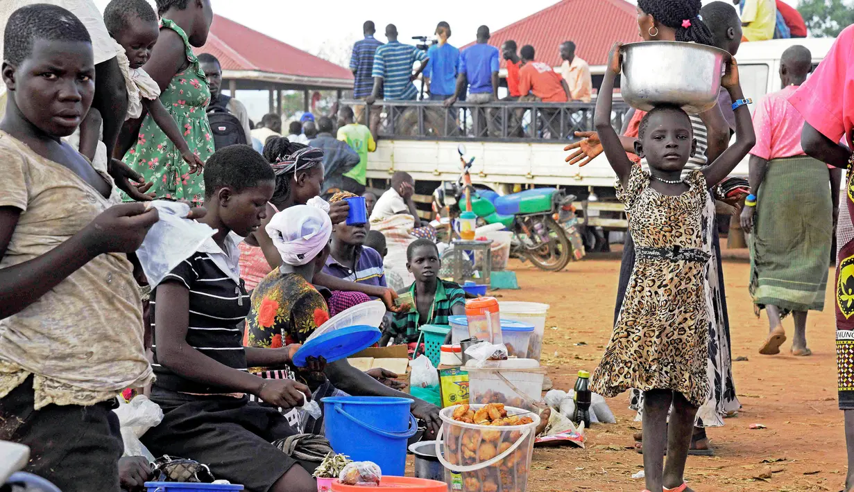 Warga menjual makanan di Pos Perbatasan Ngomoromo, Uganda, Senin (10/4). Menurut UNHCR lebih dari 6.000 orang Sudan Selatan telah melarikan diri ke distrik Uganda utara Lamwo sejak perang meletus pada 3 April. (AFP PHOTO / ISAAC KASAMANI)