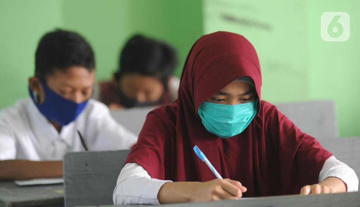 Murid baru menggunakan masker  mengikuti tes penentuan kelas tahun ajaran 2020-2021 yang selanjutnya akan mengikuti kegiatan belajar mengajar (KBM) secara darling di MTs Hidayatul Umami, Cinere, Depok, Jawa Barat, Senin (13/7/2020). (merdeka.com/Arie Basuk)
