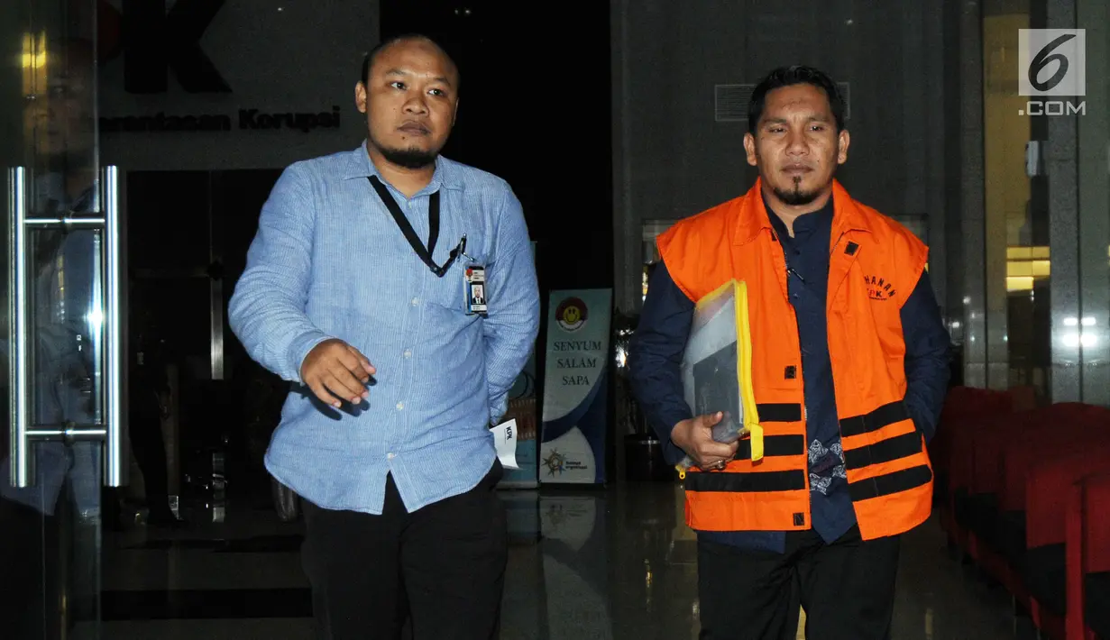 Bupati Bener Meriah Ahmadi dikawal petugas usai menjalani pemeriksaan perdana pasca ditahan OTT di Gedung KPK, Jakarta, Rabu (18/7). Ahmadi diperiksa terkait dugaan suap dana otonomi khusus Aceh tahun anggaran 2018. (Merdeka.com/Dwi Narwoko)