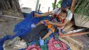 Seorang Bapak dan anaknya yang masih balita duduk pasrah saat rumahnya dibongkar petugas Satpol PP, Jakarta, Rabu (7/5/2014) (Liputan6.com/Johan Tallo).