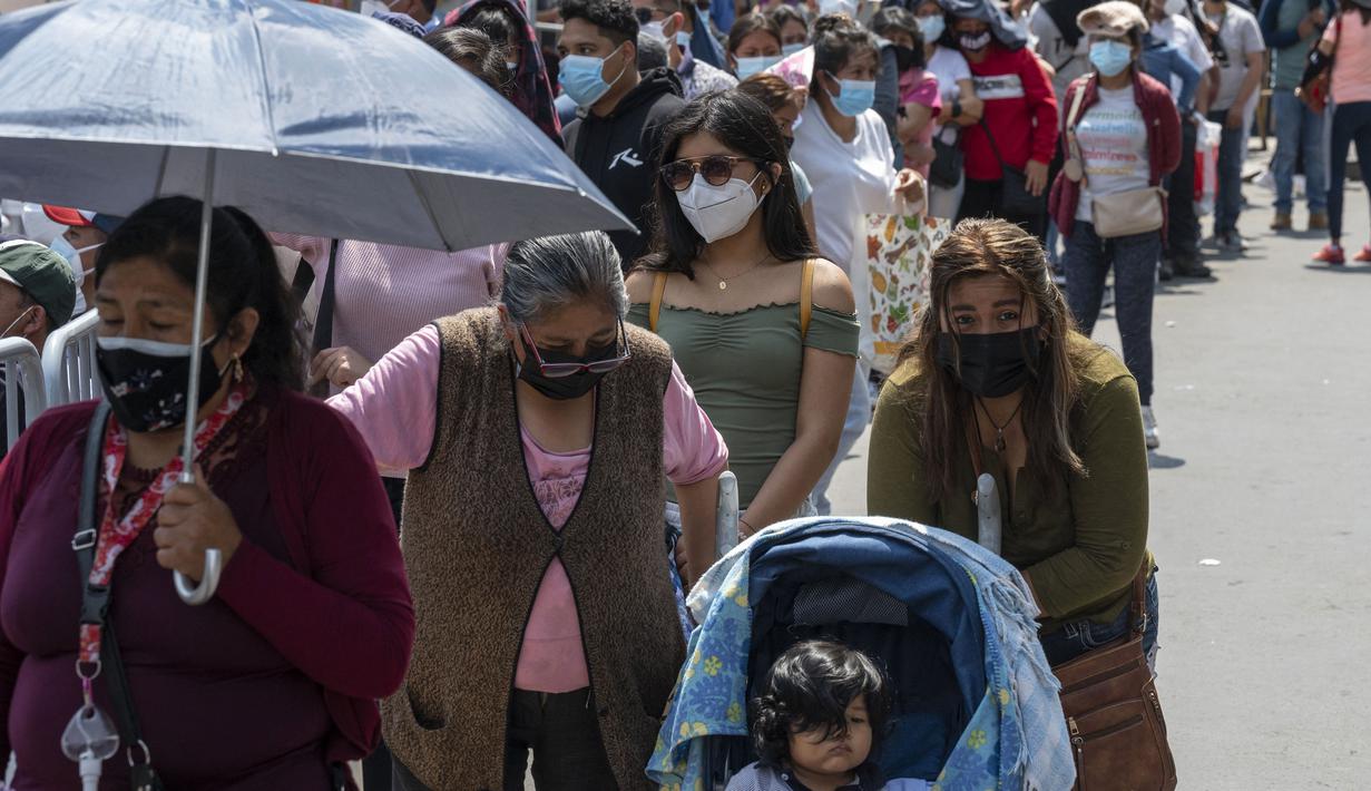 Orang-orang mengantre tes molekuler gratis dan vaksinasi di pusat kesehatan darurat di jalan di pusat kota Lima,Rabu (5/1/2022). Peru melaporkan negara itu secara resmi menghadapi gelombang ketiga COVID-19 karena peningkatan kasus infeksi setelah perayaan Natal dan Tahun Baru. (Cris BOURONCLE/AFP)