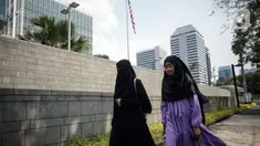 Pejalan kaki melintasi trotoar di depan Kantor Kedutaan Besar Amerika Serikat (Kedubes AS) di Jalan Medan Merdeka Selatan, Jakarta, Minggu (11/6/2023). Trotoar di depan Kedubes AS resmi kembali dibuka setelah selama 10 tahun ditutup akses bagi pejalan kaki meski petugas pengamanan tetap melakukan pemantauan. (Liputan6.com/Faizal Fanani)