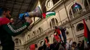 Demonstran pro-Palestina mengibarkan bendera Palestina dan meneriakkan slogan-slogan saat mereka menduduki stasiun kereta di Barcelona, Spanyol, Minggu (11/11/2023). (AP Photo/Emilio Morenatti)