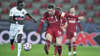 Gelandang Liverpool, Jordan Henderson mengumpan bola dari kawalan pemain Midtjylland, Pione Sisto pada pertandingan Grup D Liga Champions di MCH Arena di Herning, Denmark, Kamis (10/12/2020). Liverpool bermain imbang atas Midtjylland 1-1. (Henning Bagger/Scanpix via AP)