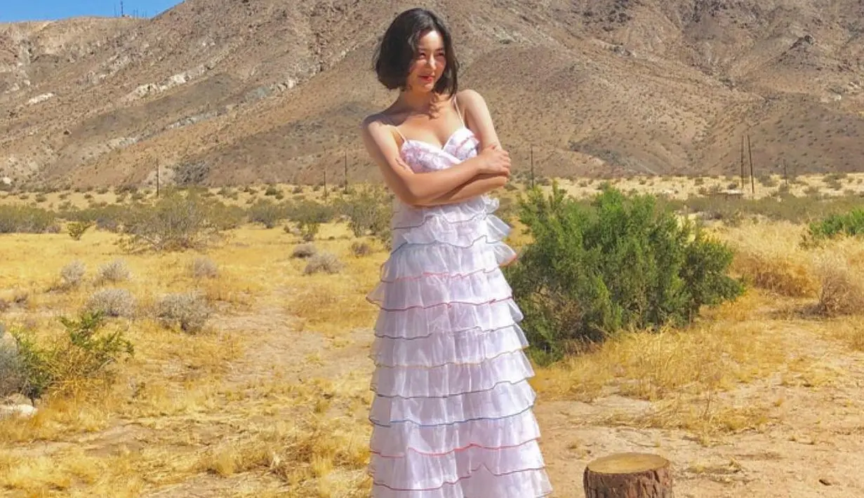 <p>Berpose di padang rumput kering, Lee Da In kembali tampil cantik. Ia mengenakan dress panjang bertali spageti dengan detail ruffles yang cantik dan bentuk hati di bagian dada. Foto: Instagram.</p>