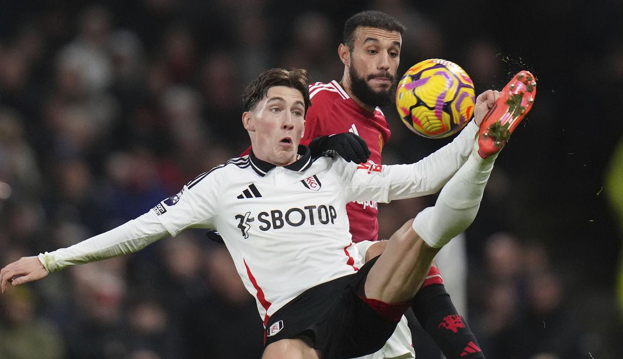 Pemain Fulham, Harry Wilson (kiri) berebut bola dengan pemain Manchester United, Lisandro Martinez pada laga lanjutan Liga Inggris 2024/2025 di Craven Cottage, London, Senin (27/01/2025) dini hari WIB. (AP Photo/Kirsty Wigglesworth)