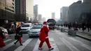 Seorang pria berpakaian seperti Santa Claus berjalan di zebra cross selama acara amal Natal di pusat kota Seoul, Korea Selatan, (24/12/2015). (REUTERS/Kim Hong-Ji)