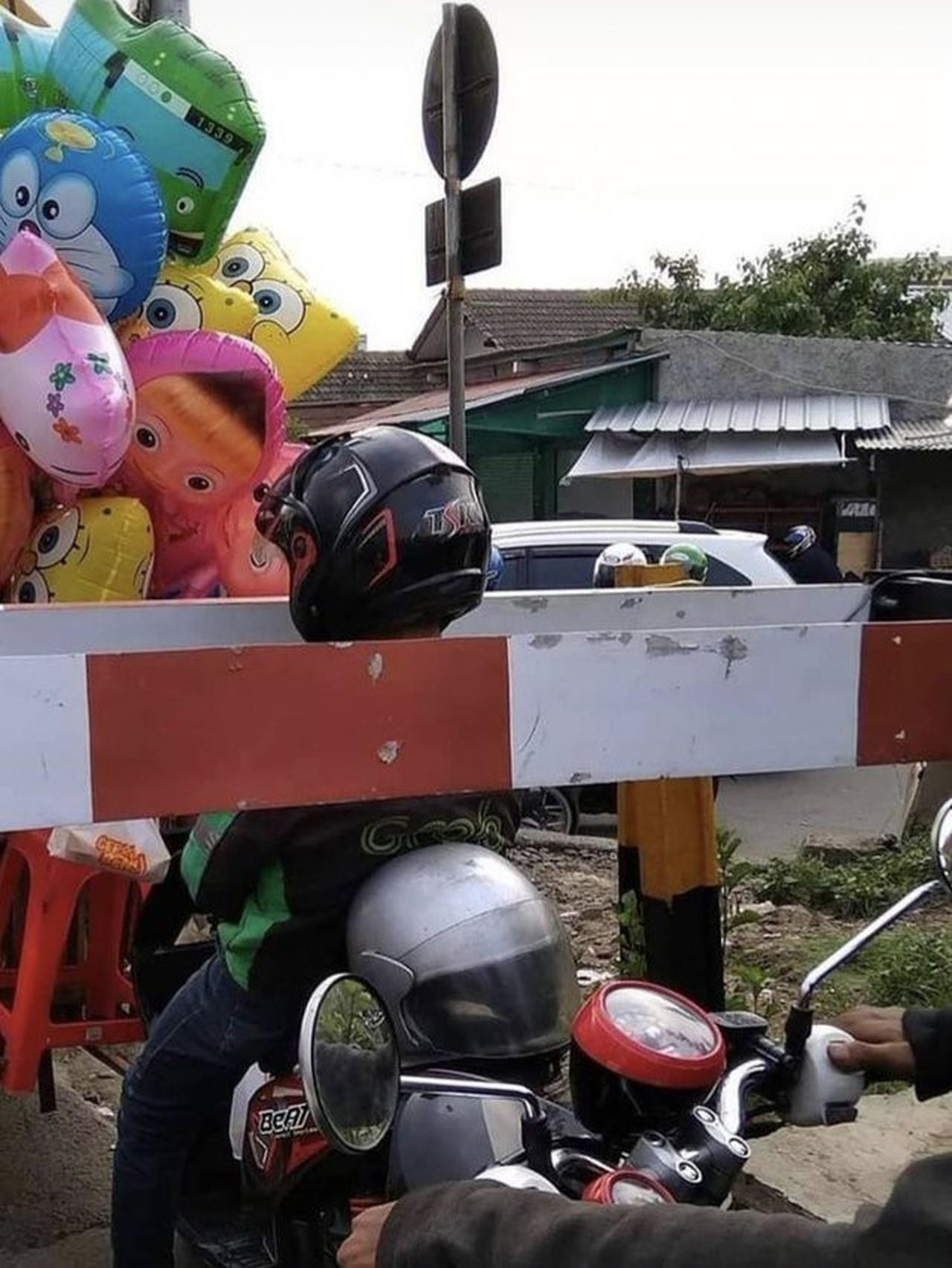Pengendara nyangkut palang pintu kereta api (Twitter/@txtdarigajelas)
