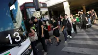 Pelayat dari provinsi luar Bangkok antri di shuttle bus gratis ke Grand Palace, untuk memberikan penghormatan terakhir kepada mendiang Raja Thailand Bhumibol Adulyadej, di stasiun kereta api Hua Lumphong, Bangkok, Thailand (15/10). (REUTERS / Edgar Su)