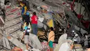 Sejumlah warga berdiri di reruntuhan bangunan untuk mencari korban pasca diguncang Gempa berkekuatan 7,8 SR, Kota Manta, Ekuador, Sabtu (16/4). Bencana tersebut menewaskan 28 orang dan diperkirakan akan bertambah. (REUTERS/Paul Ochoa)