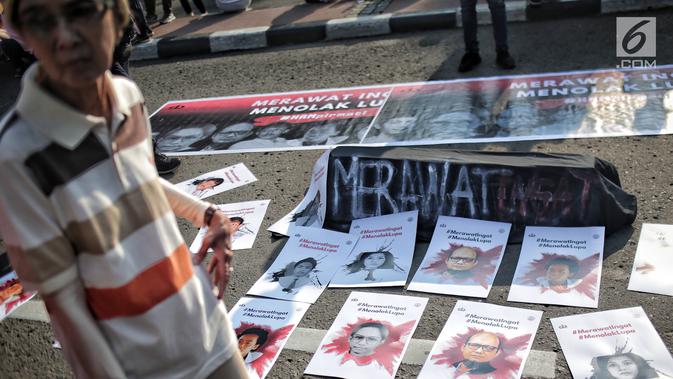 Sejumlah poster terlihat selama aksi bertajuk #MerawatIngat #MenolakLupa saat car free day (CFD) di Bundaran HI, Jakarta, Minggu (5/5/2019). Aksi tersebut bertujuan untuk mengingatkan bahwa masih banyak kasus-kasus pelanggaran HAM berat yang belum terselesaikan. (Liputan6.com/Faizal Fanani)