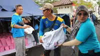 Department of CSR SIG Lovy Nurmita Sari mendistribusikan bantuan paket sembako dan kebutuhan pokok kepada perwakilan Satgas BUMN Jawa Barat, Tatang Kusdiana di Posko Satgas BUMN Jawa Barat, Kabupaten Cianjur, Jawa Barat (24/11/2022). (Liputan6.com/HO)