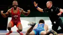 Burroughs Jordan dari AS (kiri) merayakan kemenangan usai mengalahkan Gasjimurad Omarov dari Azerbaijan dalam pertandingan gulat 74 kilogram di Freestyle Wrestling World Cup di Iowa City, Iowa (8/4). (AP Photo/Charlie Neibergall)