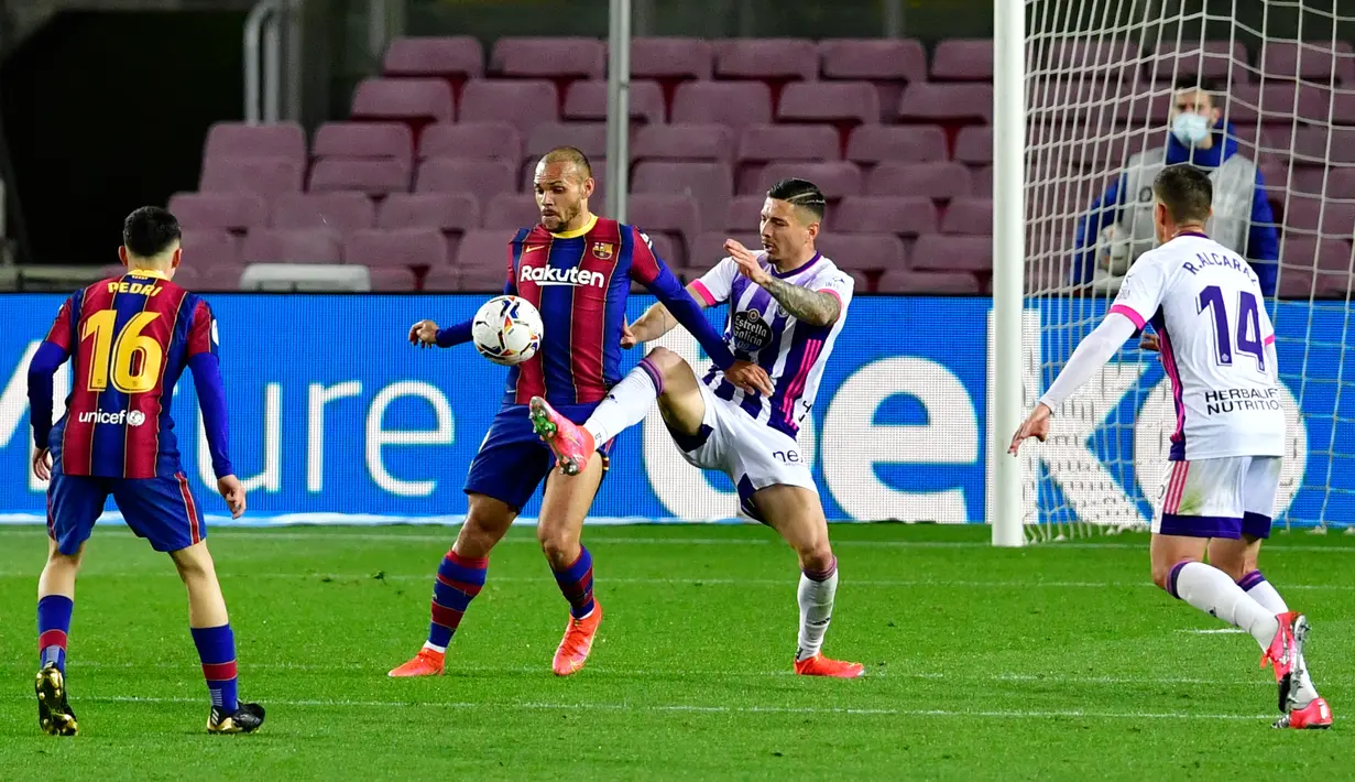 Bek Real Valladolid, Javi Sanchez (kedua kanan) berebut bola dengan penyerang Barcelona, Martin Braithwaite pada pekan ke-29 Liga Spanyol di Camp Nou, Selasa (6/4/2021) dini hari WIB. Barcelona susah payah menang tipis 1-0 berkat gol Ousmane Dembele. (Pau BARRENA/AFP)