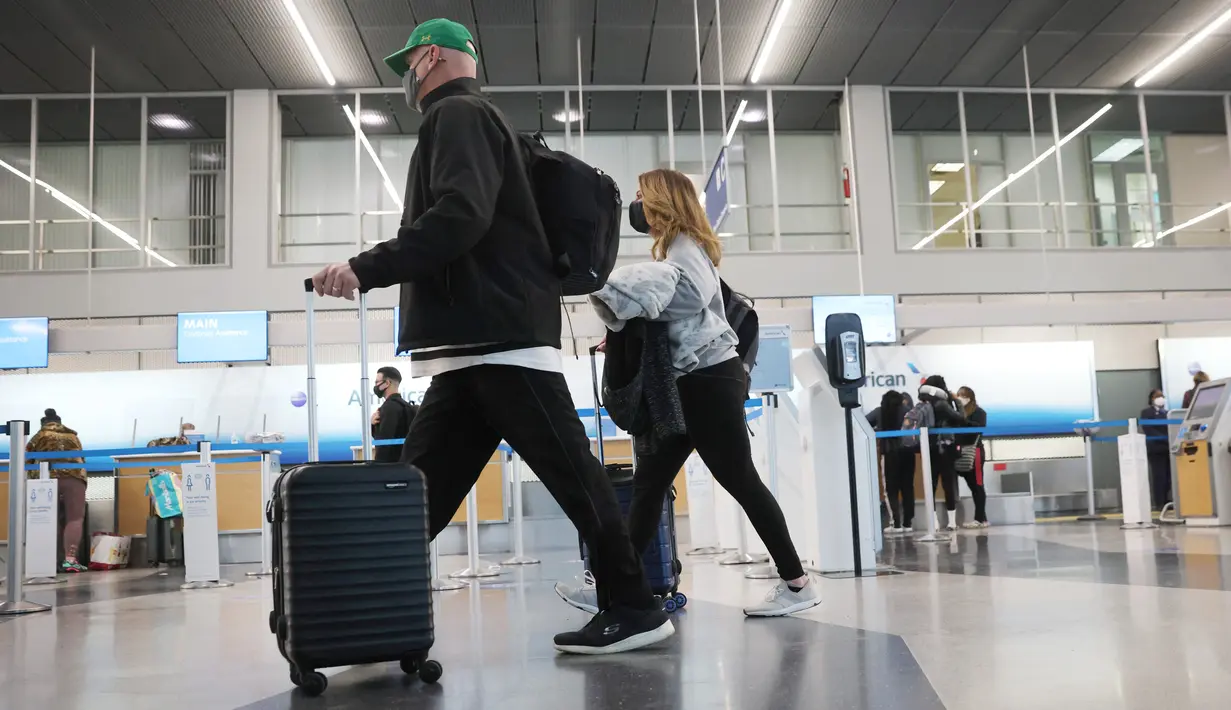 Wisatawan tiba untuk penerbangan di Bandara Internasional O'Hare di Chicago, Illinois pada 16 Maret 2021. Langkah vaksinasi COVID-19 di AS terus berlangsung hingga hari ini dan hal tersebut pun berdampak pada sektor perjalanan, termasuk perjalanan udara. (Scott Olson/Getty Images/AFP)