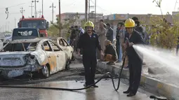 Petugas membersihkan jalan usai terjadi ledakan di Ameriyat Falluja, Irak, Jumat (18/11). Bom Mobil meledak di dekat sebuah pesta pernikahan yang menewaskan 17 orang. (Reuters/Osamah Waheeb) 
