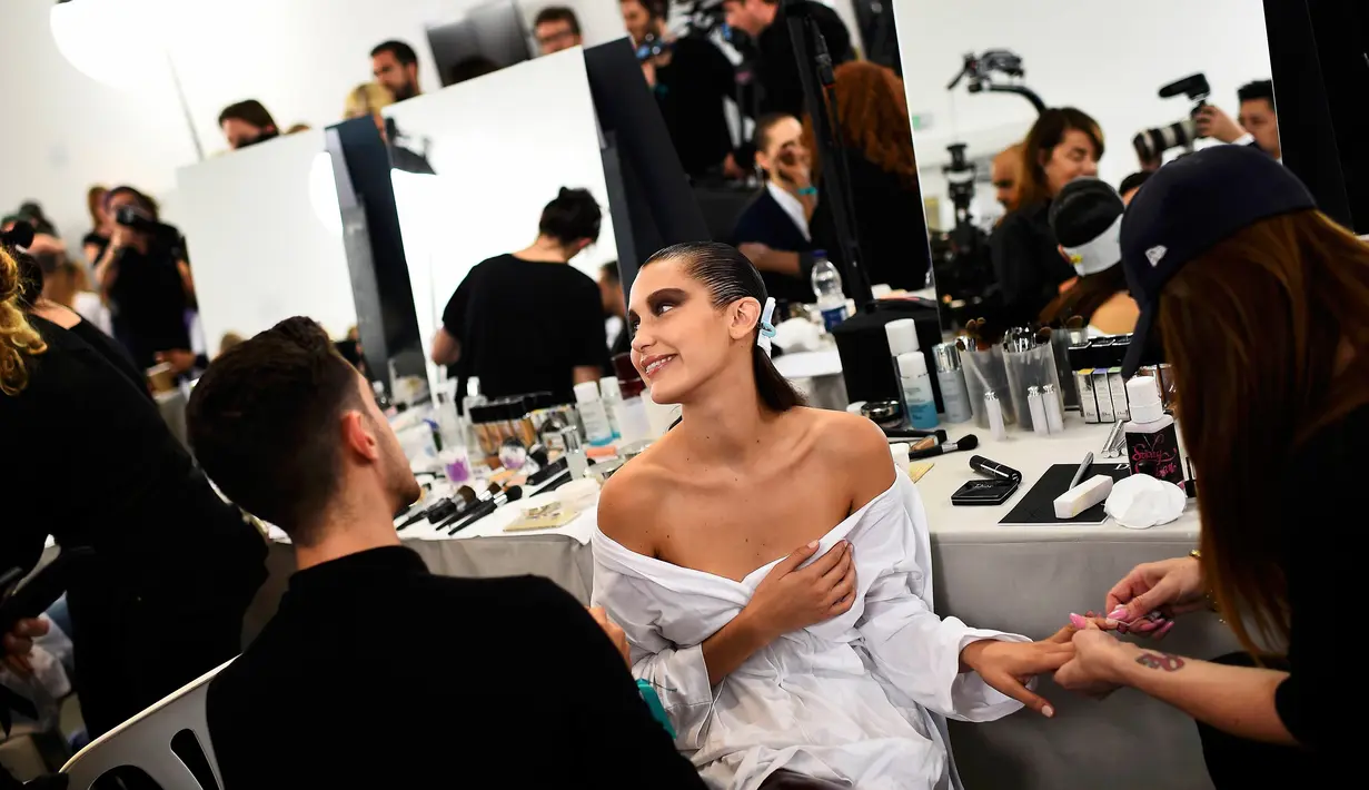 Model Bella Hadid saat make-up di belakang panggung Blenheim Palace pada peragaan busana kolehsi Dior, Cruise 2017 di Woodstock, Inggris, 31 Mei 2016. Bella Hadid sendiri merupakan adik kandung dari model terkenal Gigi Hadid. (REUTERS / Dylan Martinez)  