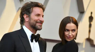 Aktor Bradley Cooper dan model asal Rusia, Irina Shayk  menghadiri perhelatan Oscar 2019 di Dolby Theatre, Los Angeles, Minggu (24/2). Di tengah isu kedekatannya dengan Lady Gaga, Cooper justru tampil mesra dengan Irina Shayk. (Jordan Strauss/Invision/AP)