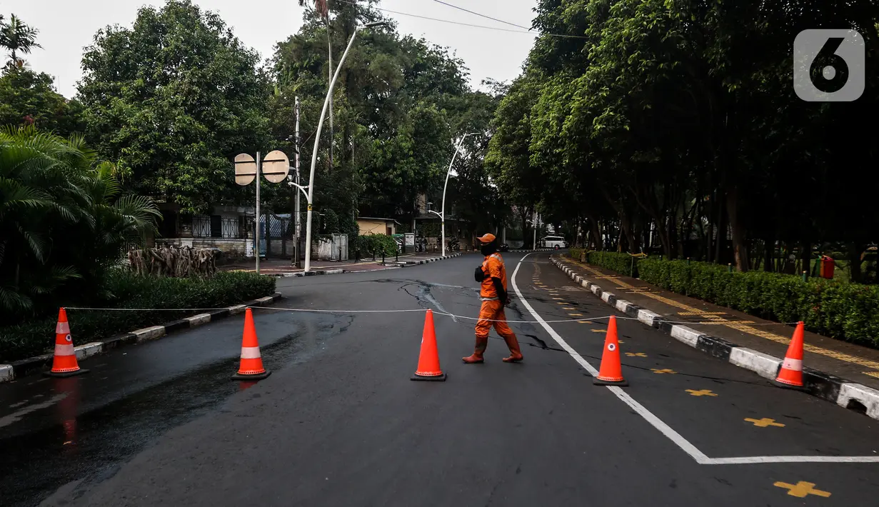 Petugas menutup area kawasan Taman Ayodya, Jalan Bulungan dan Mahakam, Jakarta, Rabu (23/9/2020). Penutupan jalan dilakukan agar masyarakat tidak berkumpul di area tersebut pada waktu malam hari dan menekan angka penularan virus corona COVID-19. (Liputan6.com/Johan Tallo)