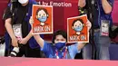 Seorang petugas mengacungkan poster yang menginstruksikan peraih medali untuk mengenakan kembali masker mereka saat seremoni penyerahan medali judo kelas 66kg putra Olimpiade Tokyo 2020, di Tokyo pada 25 Juli 2021. (AP Photo/David Goldman)