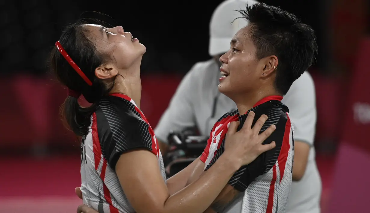 Ganda putri Indonesia Apriyani Rahayu dan Greysia Polii berselebrasi setelah menang atas pasangan China pada final badminton ganda putri Olimpiade Tokyo 2020 di Musashino Forest Sport, Senin (2/8/2021). (Alexander NEMENOV/AFP)