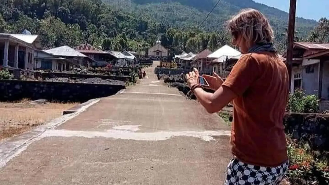 Seorang wisatawan sedang mengabadikan kampung Pajoreja yang berada persis dibawah kaki gunung ebulobo. (Foto Istimewah)