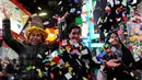 Keceriaan warga setempat saat bermain confetti dalam perayaan tahun baru di Times Square, New York, AS (1/1). Ribuan orang membanjiri Times Square untuk mengikuti acara penghitungan detik-detik pergantian tahun. (Reuters/Stephanie Keith)
