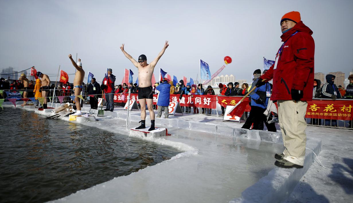Peserta bersiap ambil bagian pada Kompetisi Renang Es Harbin di Sungai Songhua yang membeku di Provinsi Heilongjiang, Senin (5/1/2016). Acara ini diselengarakan dalam rangka pembukaan Harbin International Ice and Snow Sculpture Festival (REUTERS/Aly Song)
