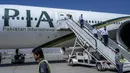 Kru pesawat turun dari penerbangan Pakistan International Airways (PIA), di bandara di Kabul, Senin (13/9/2021). Pesawat itu tercatat sebagai penerbangan komersial internasional pertama yang mendarat sejak Taliban merebut kembali kekuasaan di Afghanistan pada Agustus lalu. (Bulent KILIC/AFP)