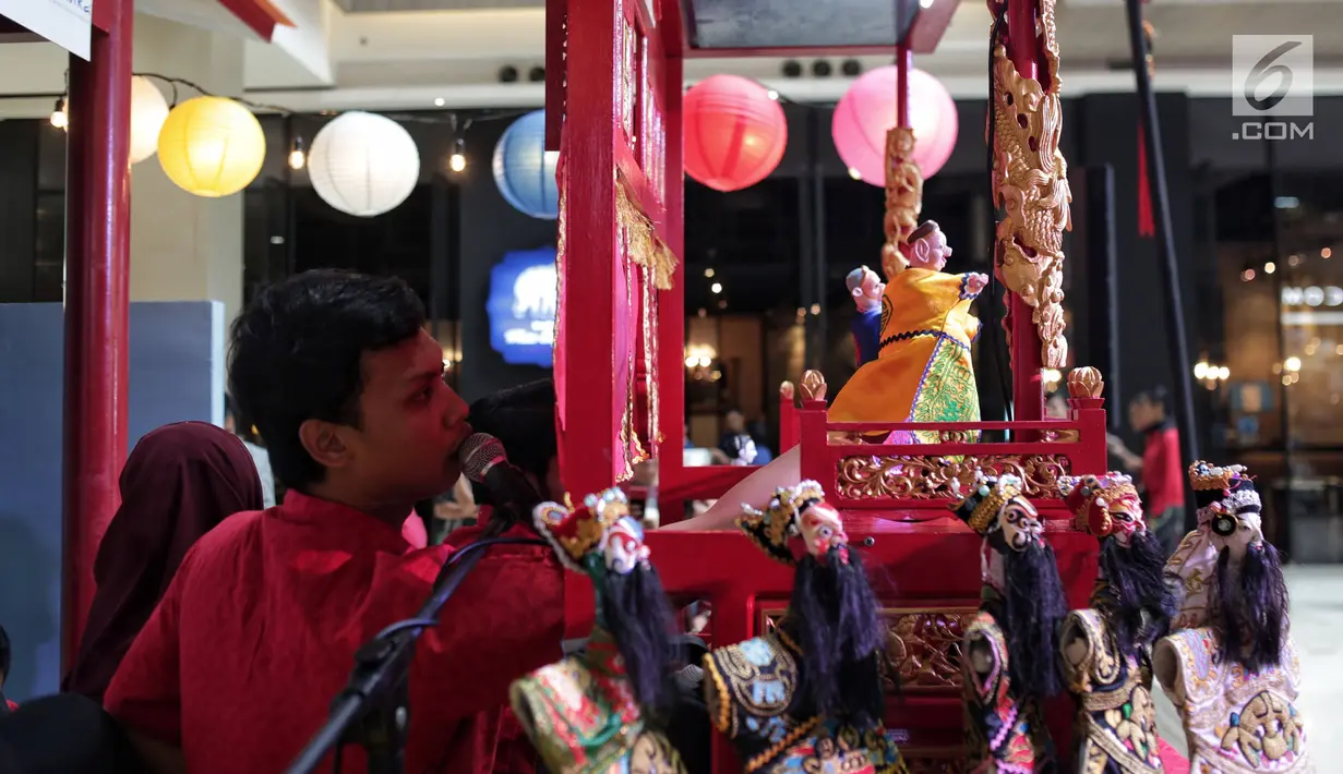 Seorang dalang memainkan wayang potehi di salah satu mall di Jakarta, Jumat (1/2). Pementasan wayang potehi  tersebut diadakan dalam rangka menyambut Tahun Baru Imlek. (Liputan6.com/Faizal Fanani)