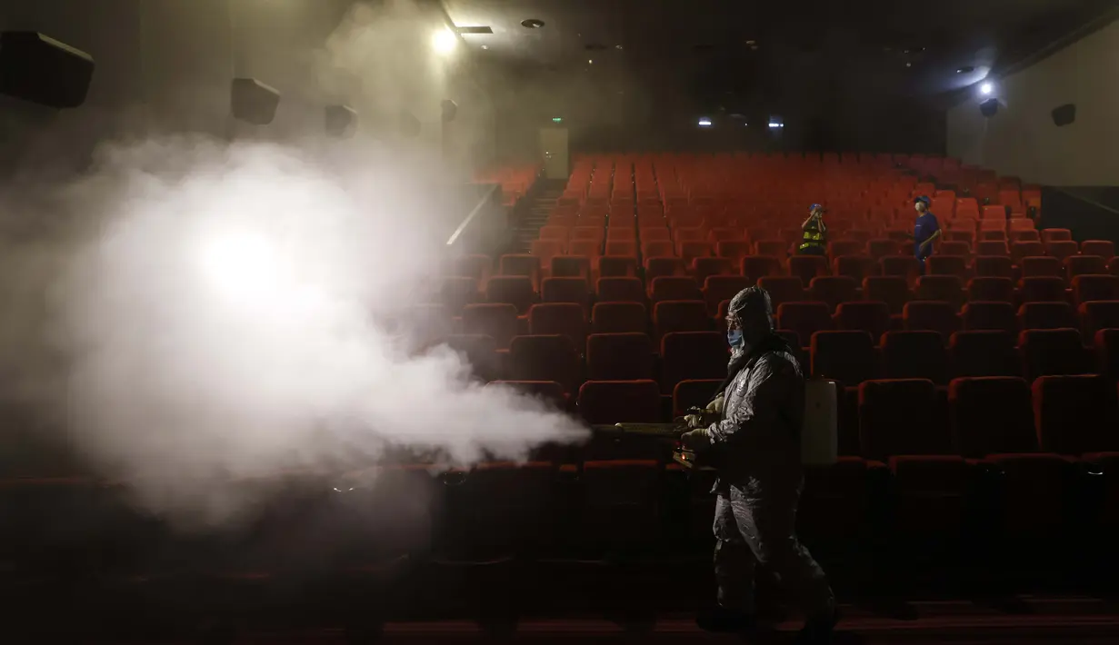 Sukarelawan bersama tim Blue Sky Rescue melakukan disinfektan pada teater di Beijing pada 24 Juli 2020. Bioskop di China, pasar film terbesar kedua di dunia, minggu ini dibuka kembali dari coronavirus yang ditutup dengan teater terbatas dengan Kapasitas 30 persen. (AP Photo / Ng Han Guan)