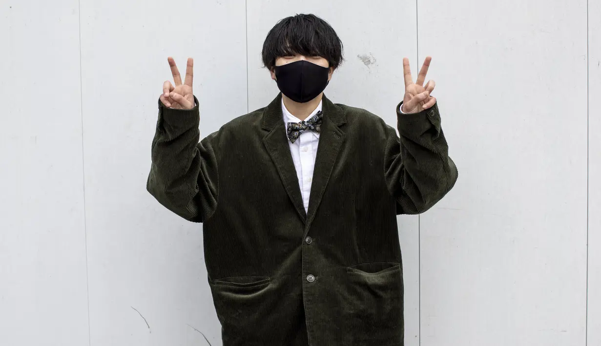 Nagomi Tanahara berusia 20 tahun mengenakan jas hitam berpose di luar Todoroki Arena selama upacara perayaan "Coming-of-Age Day" di Kawasaki, prefektur Kanagawa (11/1/2021). Lebih dari 1 juta anak muda di Jepang berulang tahun yang ke-20 pada 2021.  (AFP/Behrouz Mehri)