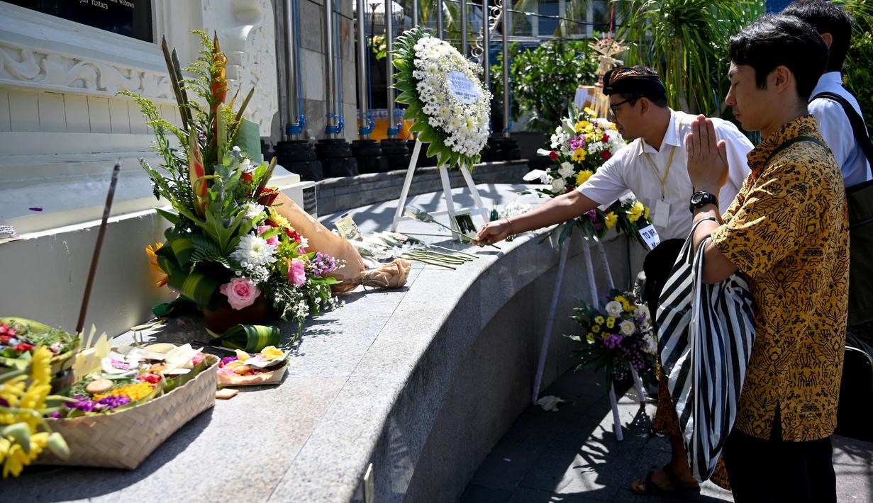 Seorang pria asal Jepang berdoa di Monumen Bom Bali, Kuta, dekat Denpasar pada Sabtu (12/10/2019). MeMperingati 18 tahun peristiwa bom Bali yang terjadi pada 12 Oktober 2002, wisatawan dan kerabat korban mengunjungi tugu peringatan untuk berdoa dan tabur bunga. (SONNY TUMBELAKA / AFP)